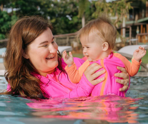 Mom and daughter in matching neon pink long-sleeve rash guards by SwimZip—What colors should you avoid in a swimming pool (and why)?