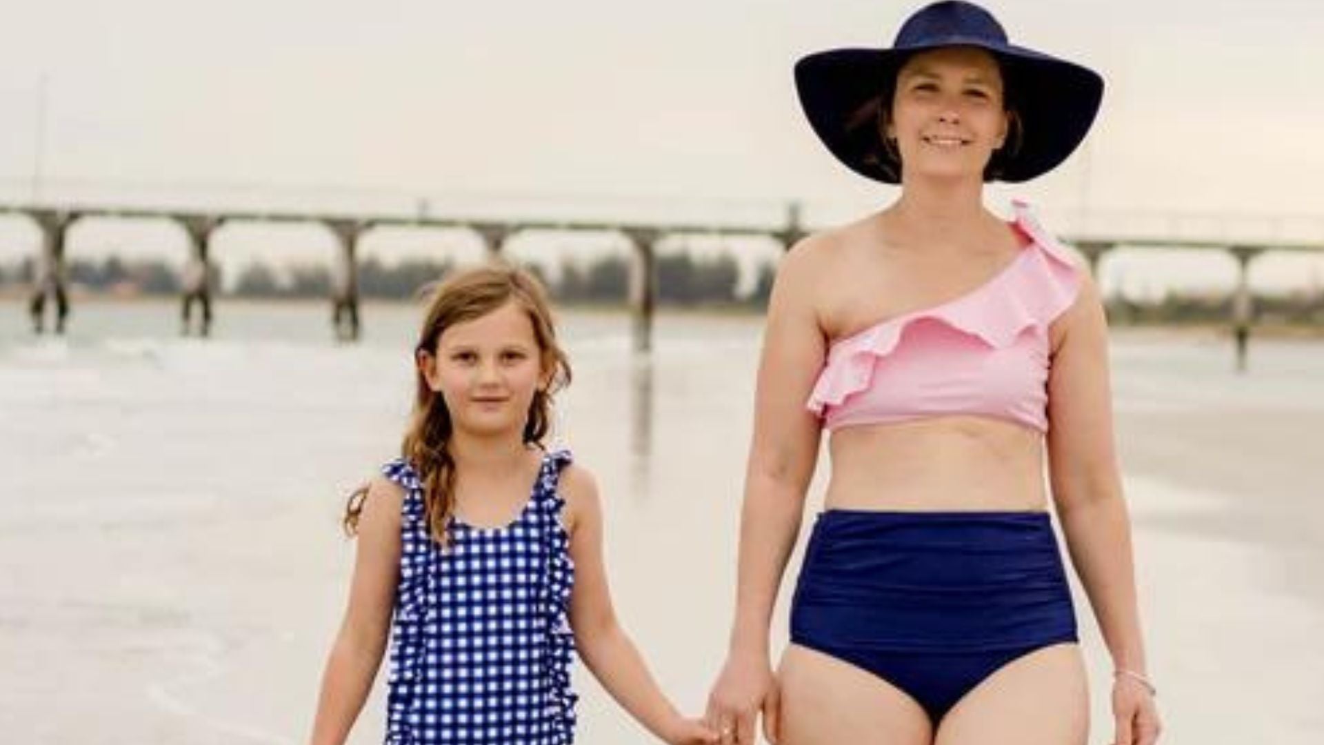 Mother and daughter in SwimZip sun protective swimwear on the beach—Bikini bottom styles and types explained