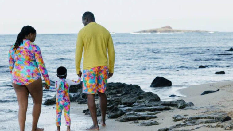 Family in a matching SwimZip swimwear by the ocean—What is the best swimsuit color to wear in the ocean
