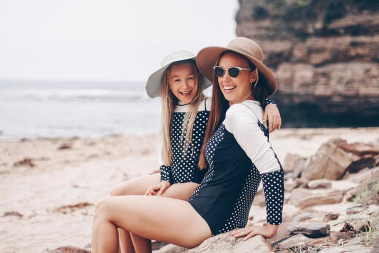 Mother and daughter at beach in mommy and me matching swimsuits—How to shrink a swimsuit.
