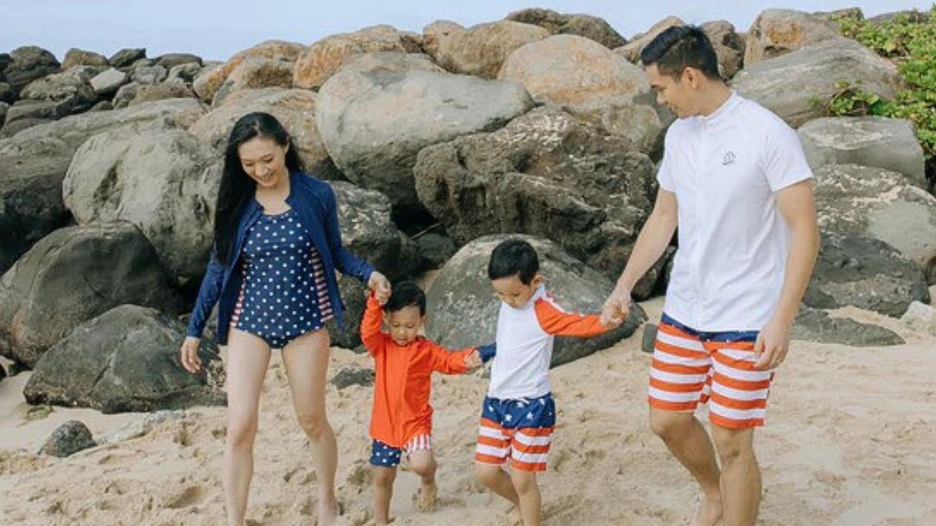 Family in Americana matching sun-protective swimwear enjoys time at the beach—Sun safe family swimwear ideas