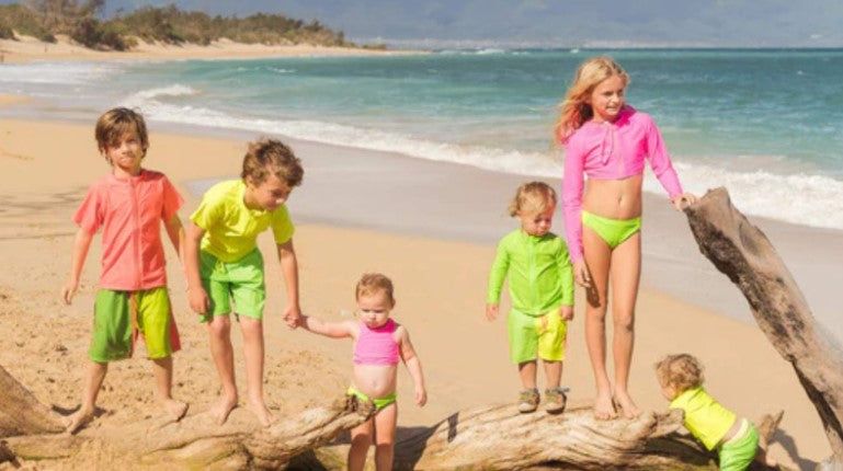 Kids in the neon swimwear by SwimZip at the beach—What swimwear color should kids avoid?