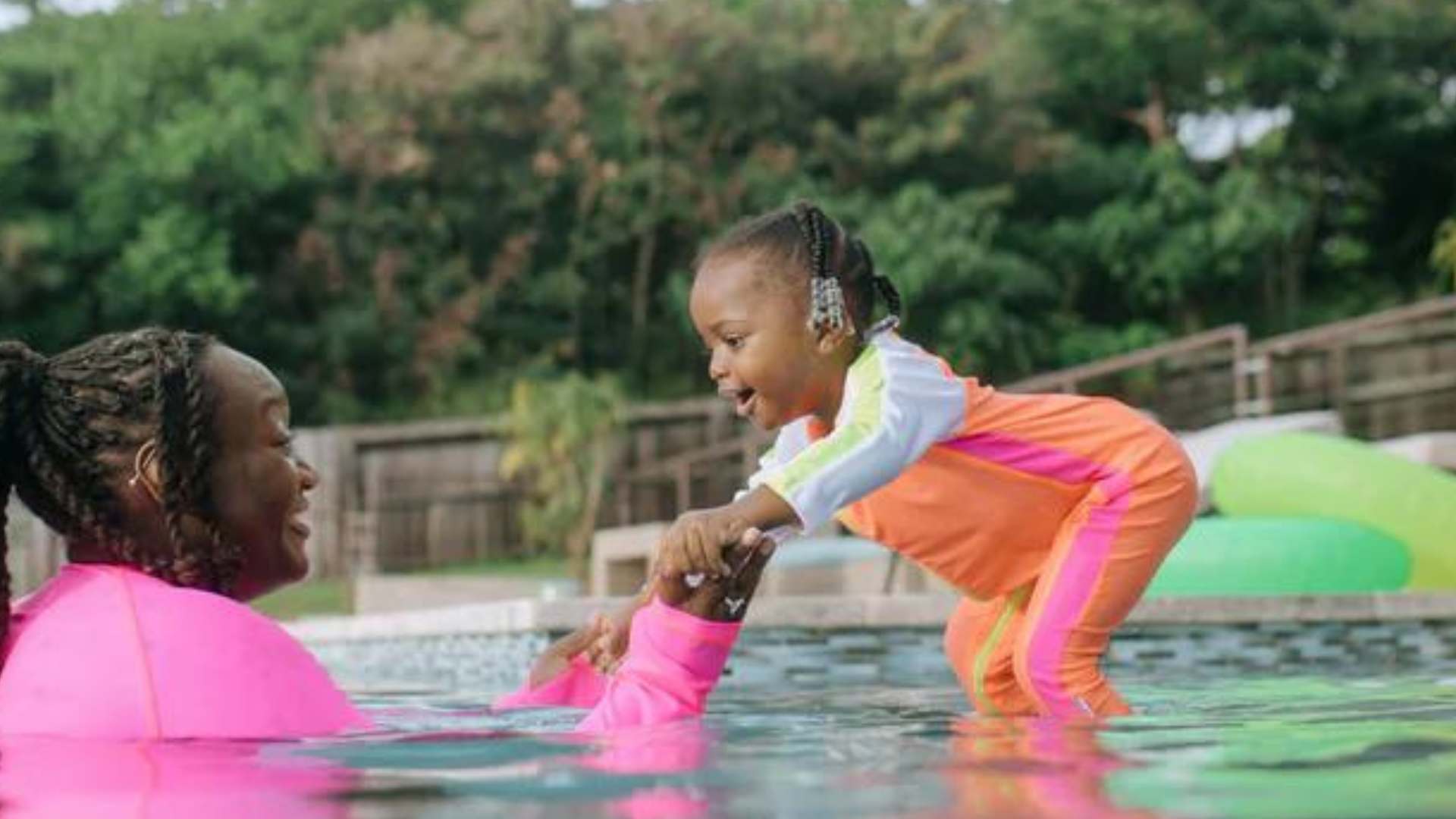 Mom and daughter in SwimZip neon swimsuits play in the water—What is the best color swimsuit for visibility underwater?