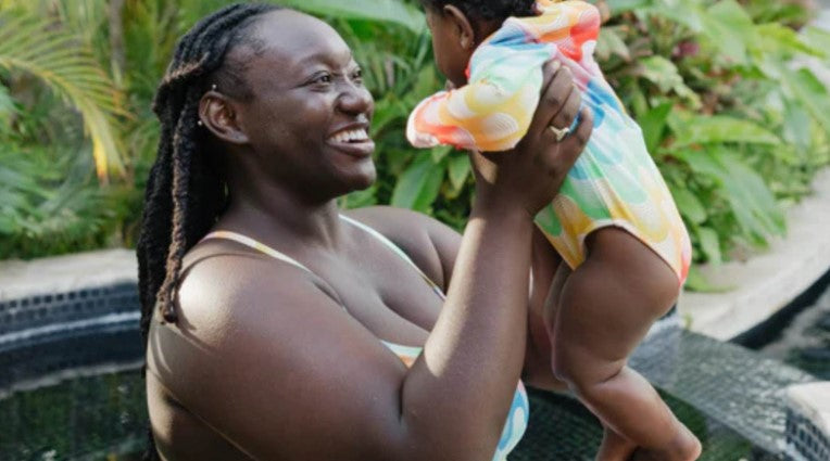 Woman with apple body shape with her baby in SwimZip swimwear—Best swimsuits for apple body shapes (and what to avoid)